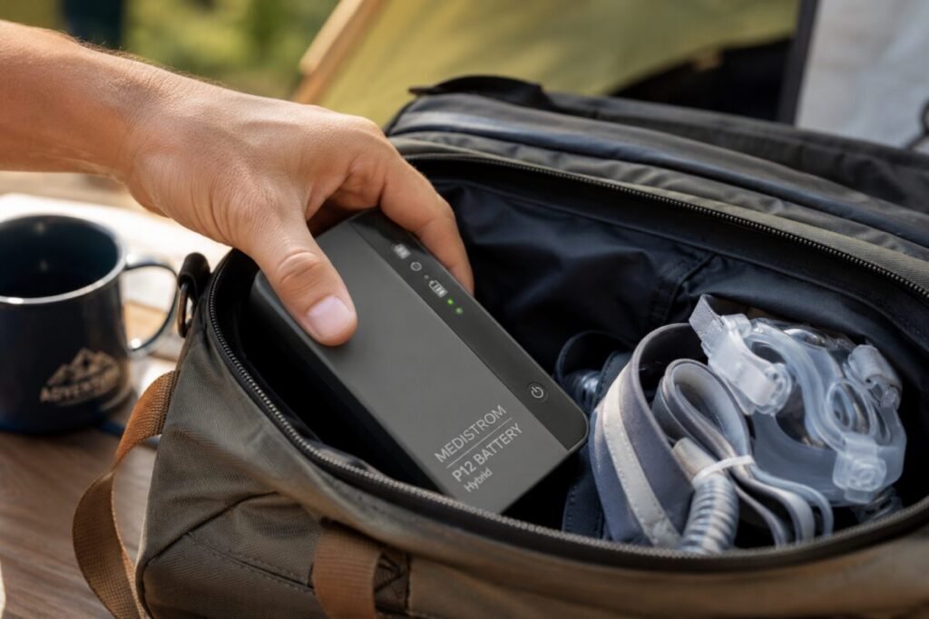 Packing a Medistrom CPAP battery and CPAP mask into a travel bag before a camping trip