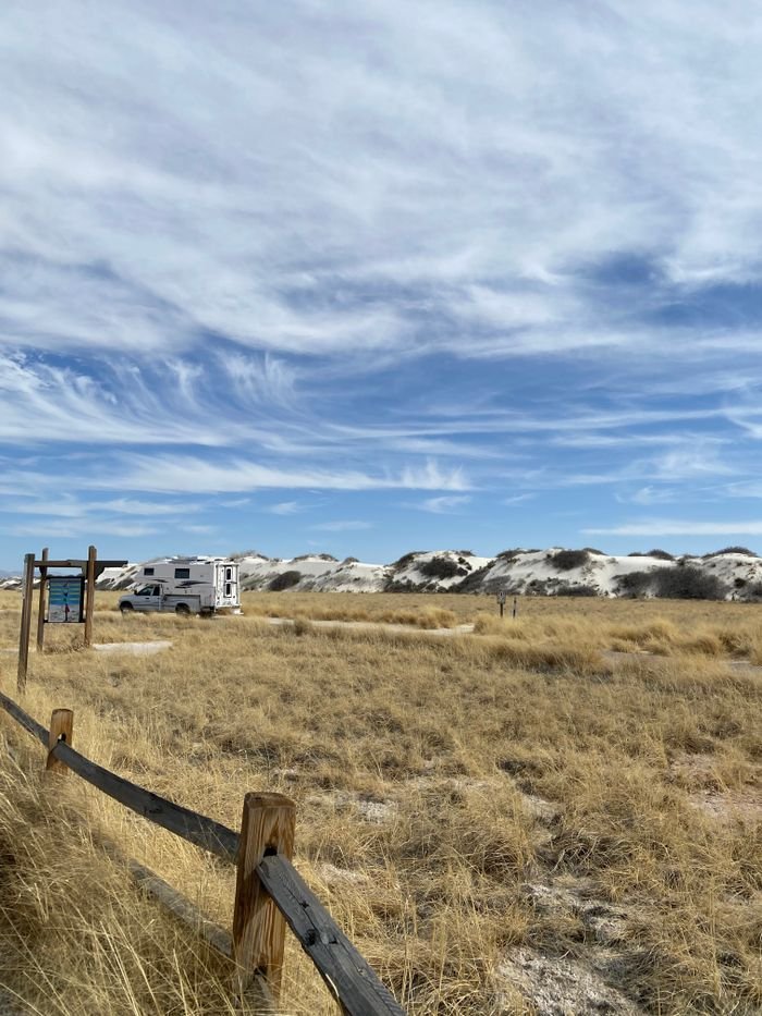 Explore the serene landscapes of White Sands, New Mexico with a parked RV adding charm to the vast sandy dunes.