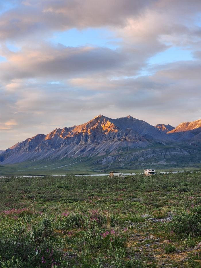 Stunning sunset over the Brooks Range, Coldfoot, Alaska showcasing mountains and expansive landscape.