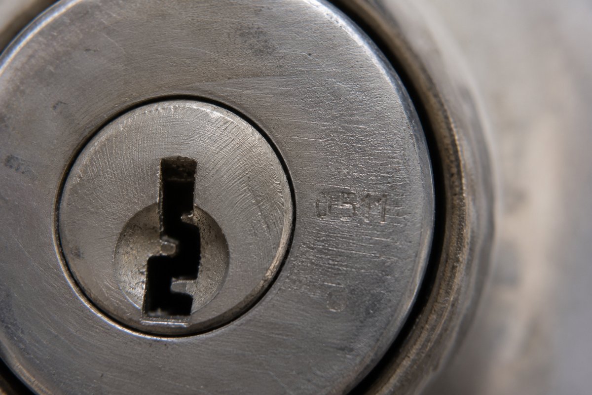 Close up of an RV lock cylinder with a short key code stamped into the face beside the keyway