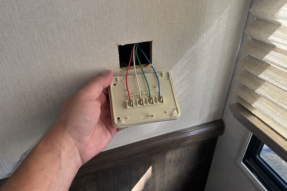 Four wires landing on the screw terminals behind an RV thermostat back plate