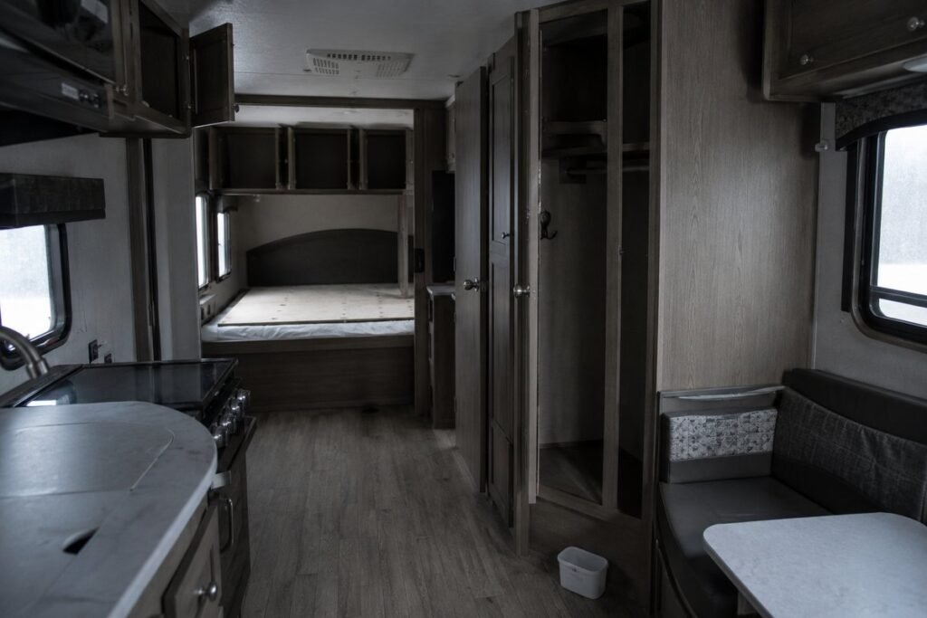 Stored travel trailer interior with cabinets propped open and an RV dehumidifier in place